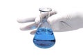 Hand in rubber glove holding chemical flask with blue liquid Royalty Free Stock Photo