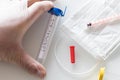 Hand in a rubber glove holding a laboratory vial with coronovirus, concept, epidemiological threat