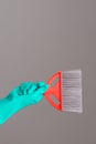 A hand in a rubber glove holds panicle on a neutral background.