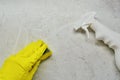 A hand in a rubber glove and a yellow glove washes the tiles with a sponge Royalty Free Stock Photo
