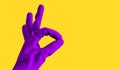 Hand in rubber violet glove shows ok sign, isolated object on yellow background for design with copy space. cleaning concept