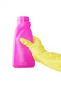 Hand in rubber yellow glove holds pink bottle of liquid bleach on white background. cleaning Royalty Free Stock Photo