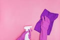 Hand in a rubber yellow glove holds pink bottle of liquid bleach on a white background. cleaning Royalty Free Stock Photo