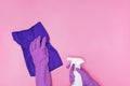 Hand in a rubber yellow glove holds pink bottle of liquid bleach on a white background. cleaning Royalty Free Stock Photo