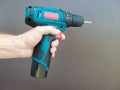 Hand 's man with screwdriver. The worker using an electric drill screwdriver, close-up. Concept of repair and construction Royalty Free Stock Photo