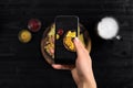 Hand`s of woman taking picture photo food with mobile smart phone. Top view. Mexican nachos with two kind sauce on photo Royalty Free Stock Photo
