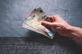 HandÃÂ´s of young man holding a money. Banknotes on a stone background. Euro money bank notes of different value. Royalty Free Stock Photo