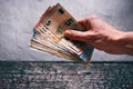 HandÃÂ´s of young man holding a money. Banknotes on a stone background. Euro money bank notes of different value. Royalty Free Stock Photo