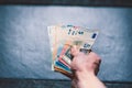 HandÃÂ´s of young man holding a money. Banknotes on a stone background. Euro money bank notes of different value.