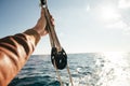 Hand of sailor holds onto rope in pulley Royalty Free Stock Photo