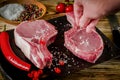 hand salt meat steak. Raw marbled meat steak, pepper, herbs, garlic, old wooden background. Space for text. Beef Rib eye steak Royalty Free Stock Photo