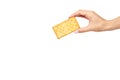 Hand with salty cracker, crispy appetizer, rectangle shape cookie. Isolated