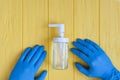 Hand sanitizer bottle and blue gloved hands close up. Call for hand disinfection. Stop coronavirus concept. Using