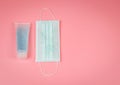 Hand Sanitizer and Disposable Hygienic Mask on pink background with copy space. protection against pm2.5 and COVID-19 concept