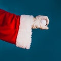Hand of Santa Claus in white leather golf glove is holding a golf ball on a blue background with copy space Royalty Free Stock Photo