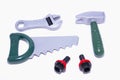 Hand saw, wrench, hammer and two black screws with red toy nuts