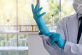 Scientist or doctor putting blue latex gloves in laboratory. Safety work concept