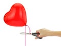 Hand with a scissor cutting a red heart shape balloon ribbon isolated on white Ãâreaking up, separation concept