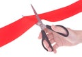 Hand with scissors cutting red ribbon Royalty Free Stock Photo