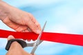 Hand with scissors cutting red ribbon - opening ceremony Royalty Free Stock Photo