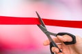 Hand with scissors cutting red ribbon - opening ceremony Royalty Free Stock Photo