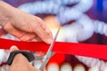 Hand with scissors cutting red ribbon - opening ceremony Royalty Free Stock Photo