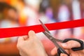Hand with scissors cutting red ribbon - opening ceremony Royalty Free Stock Photo