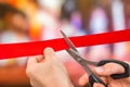 Hand with scissors cutting red ribbon - opening ceremony