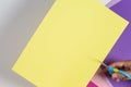 Hand with scissors cutting sheet of yellow color paper Royalty Free Stock Photo