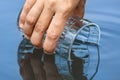 Hand scooping water from a clean pond