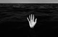 Hand on the sea of a person who is drowning black and white tones