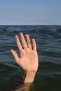 Hand in the sea of a person who is drowning