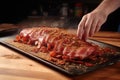 hand seasoning a slab of bacon for smoking