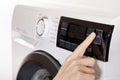 The hand select settings for laundry on modern digital display. Close-up view of automatic washing machine with touch screen on