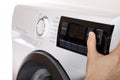 The hand select settings for laundry on modern digital display. Close-up view of automatic washing machine with touch screen on