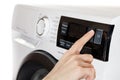 The hand select settings for laundry on modern digital display. Close-up view of automatic washing machine with touch screen on Royalty Free Stock Photo