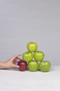 Hand selecting an apple from a stack