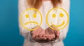 A Hand is selecting a happy mood smiley. In front of an empty room Royalty Free Stock Photo