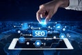 Hand Selecting SEO Icons Over Digital Tablet on World Map Background, Representing Data Mining, Keywords, Best Practices Royalty Free Stock Photo