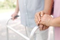 Hand of senior couple using walker in park