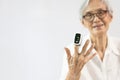 Hand of senior woman with an attached pulse oximeter on fingertip,old elderly measuring heart rate,checking oxygen saturation