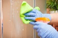 Hand of senior woman cleaning glass shower using microfiber cloth and detergent, household duties concept Royalty Free Stock Photo