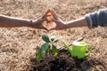 The hand of the senior woman and the hand of young women are make heart sign after helping each other to plant trees, World Royalty Free Stock Photo