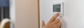 Hand sets a programmable thermostat for heating and cooling Royalty Free Stock Photo