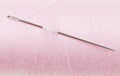 Hand sewing needle in pink thread bobbin