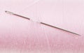 Hand sewing needle in pink thread bobbin Royalty Free Stock Photo