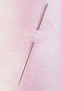 Hand sewing needle in pink thread spool Royalty Free Stock Photo