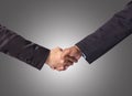 Hand shake between a businessman on gray background