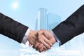 Hand shake between a businessman on Modern business building glass area background Royalty Free Stock Photo