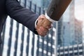 Hand shake between businessman,successfully negotiated and achieved excellent commercial cooperation,background city landscape and